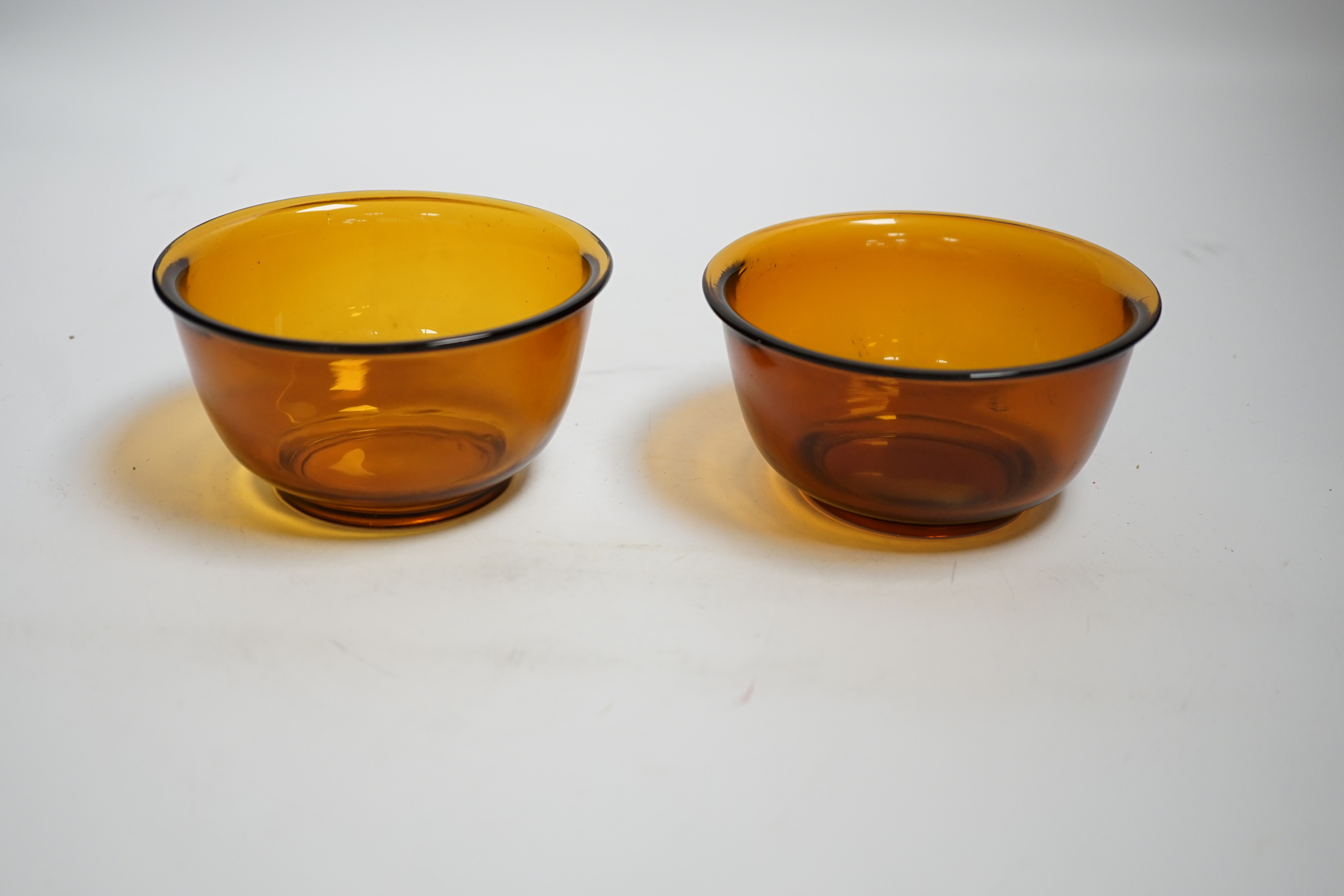 A pair of Chinese Beijing amber glass bowls, 11cm diameter